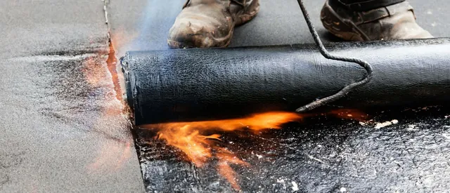A Balmoral Flat Roofing operative torch-applying built-up felt to a flat roof in Nottinghamshire