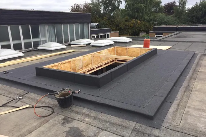 Balmoral Flat Roofing operative installing insulation boards on a flat roof deck